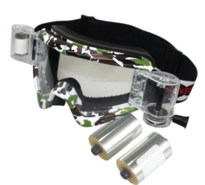 The image shows a pair of camouflage-patterned goggles with an attached GoPro-style camera mount and two cylindrical film canisters. The goggles have a black elastic strap. The overall impression is of equipment for action sports or outdoor activities where video recording is desired. 